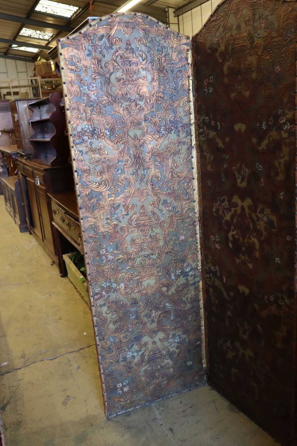 A Spanish embossed leather four-fold screen with painted and gilded leaf, flower and scroll decoration, 198 x 61cm (per panel)